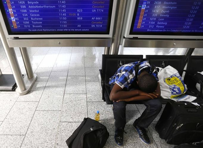 A passenger sits under a monitor with a flight schedule as he waits for a transfer at the Fraport airport in Frankfurt, September 4, 2012. German air carrier Lufthansa passengers face widespread flight disruption after cabin crew representatives said they continue a series of strikes over pay and cost-cutting measures at Germany's largest airline. The UFO union, which represents around two-thirds of Lufthansa's 19,000 cabin crew, late on Thursday called on its members to strike in Frankfurt and Berlin. REUTERS/Kai Pfaffenbach (GERMANY - Tags: BUSINESS EMPLOYMENT CIVIL UNREST TRANSPORT) Published: Zář. 4, 2012, 12:36 odp.