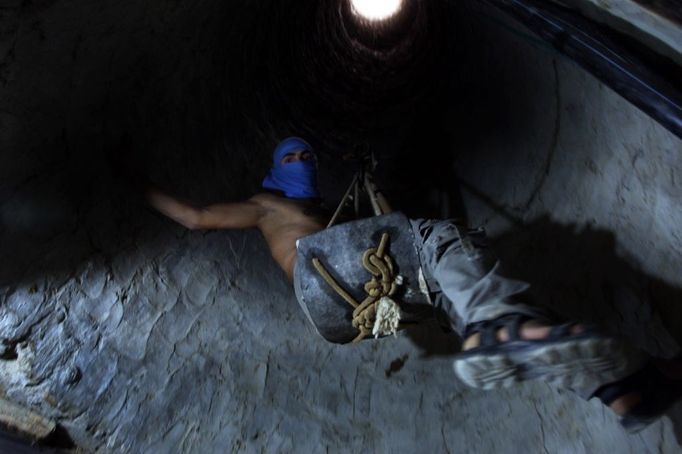 14 Titulek: Gaza's tunnel mugglers on Egypt border mostly idle Popis: A Palestinian tunnel-digger lowers himself into the smuggling tunnel beneath the Egyptian-Gaza border in Rafah in the southern Gaza, October 8, 2013. Gaza's tunnel smugglers along the border with Egypt are mostly idle these days. Since the summer, Egypt's military has tried to destroy or seal off most of the smuggling tunnels under the Gaza-Egypt border, a consequence of the heightened tensions between Cairo and the Hamas government in Gaza which is suffering a bad economic recession.