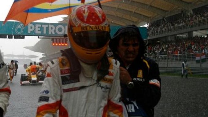 Fernando Alonso odchází za hustého deště od svého monopostu.