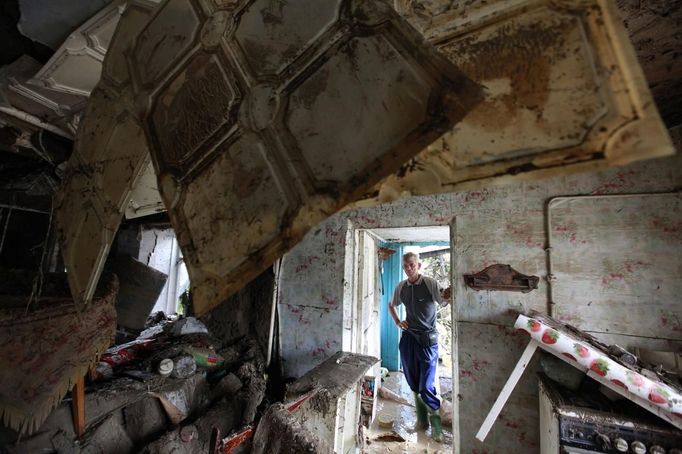 A local resident looks at the debris of a house damaged by floods in the town of Krymsk in Krasnodar region, southern Russia, July 8, 2012. Russian President Vladimir Putin ordered investigators to find out if enough was done to prevent 144 people being killed in floods in southern Russia after flying to the region to deal with the first big disaster of his new presidency. REUTERS/Eduard Korniyenko (RUSSIA - Tags: DISASTER ENVIRONMENT POLITICS) Published: Čec. 8, 2012, 7:07 dop.