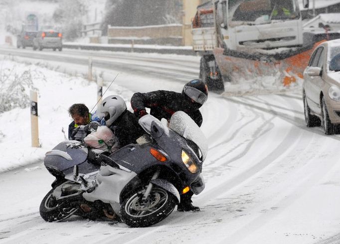 Muž se snaží zvednout motorku poté, co ji "položil" na bok na severu Španělska, poblíž Campomanes.