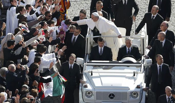 Pope Francis leans out to touch a child's head as he arrives in Saint Peter's Square for his inaugural mass at the Vatican, March 19, 2013. Pope Francis celebrates his inaugural mass on Tuesday among political and religious leaders from around the world and amid a wave of hope for a renewal of the scandal-plagued Roman Catholic Church. REUTERS/Paul Hanna (VATICAN - Tags: RELIGION POLITICS TPX IMAGES OF THE DAY) Published: Bře. 19, 2013, 8:41 dop.