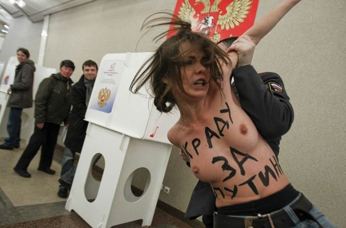 Aktivistka hnutí Femen "řádí" ve volební místnosti, kde hlasoval Vladimir Putin.