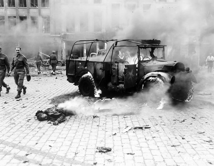 This boy's dead, burning body shows damage done by a V-2 on a main intersection in Antwerp, on a main supply line to Holland.