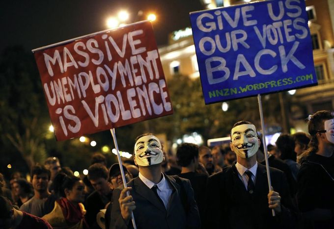 Protesters wearing hold up placards as anti-austerity demonstrators continued into the night near the Spanish parliament in Madrid, September 25, 2012. Anti-austerity demonstrators protested in Madrid ahead of the government's tough 2013 budget that will cut into social services as the country teeters on the brink of a bailout. REUTERS/Paul Hanna (SPAIN - Tags: POLITICS CIVIL UNREST BUSINESS) Published: Zář. 25, 2012, 11:12 odp.