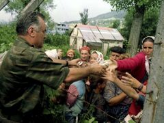 Ratko Mladič na fotografii z 12. července 1995 podává pití muslimských uprchlicím, čekajícím na odvoz z Potočari.
