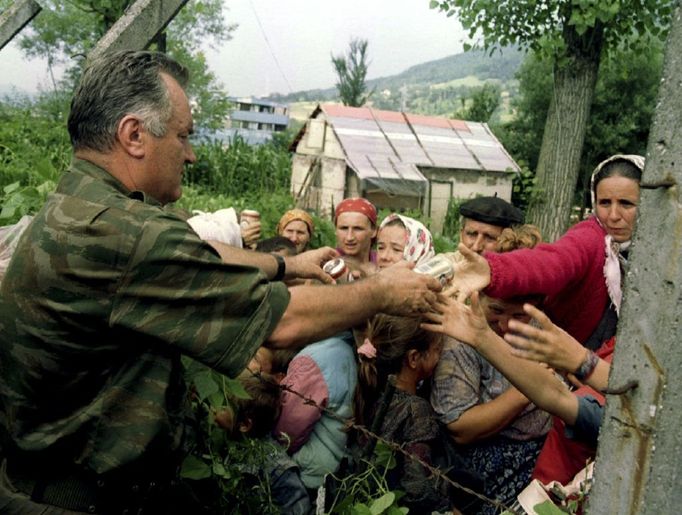 Ratko Mladič na fotografii z 12. července 1995 podává pití muslimských uprchlicím, čekajícím na odvoz z Potočari.