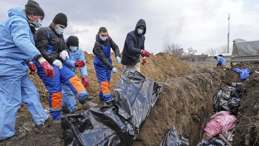 Pohřbívání těl obětí ruského ostřelování obklíčeného Mariupolu na Ukrajině do masového hrobu. Mariupol, Ukrajina, 9. 3. 2022