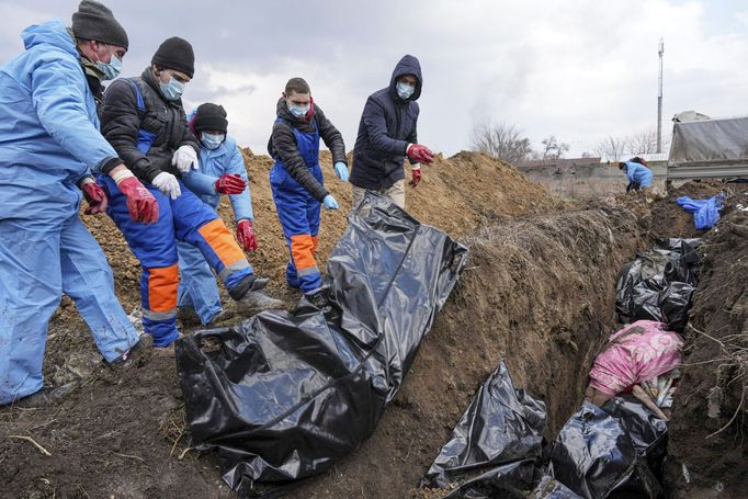 Pohřbívání těl obětí ruského ostřelování obklíčeného Mariupolu na Ukrajině do masového hrobu. Mariupol, Ukrajina, 9. 3. 2022