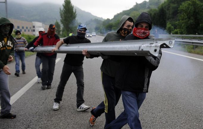 Miners on strike move to set up a barricade on the A-66 motorway, on the first day of a strike to protest the government's spending cuts in the mining sector, in Pola de Lena, near Oviedo, northern Spain, May 23, 2012. Spain's economy is contracting for the second time since late 2009 and four years of stagnation and recession have pushed unemployment above 24 percent, the highest rate in the European Union. REUTERS/Eloy Alonso (SPAIN - Tags: CIVIL UNREST BUSINESS EMPLOYMENT POLITICS) Published: Kvě. 23, 2012, 11:08 dop.