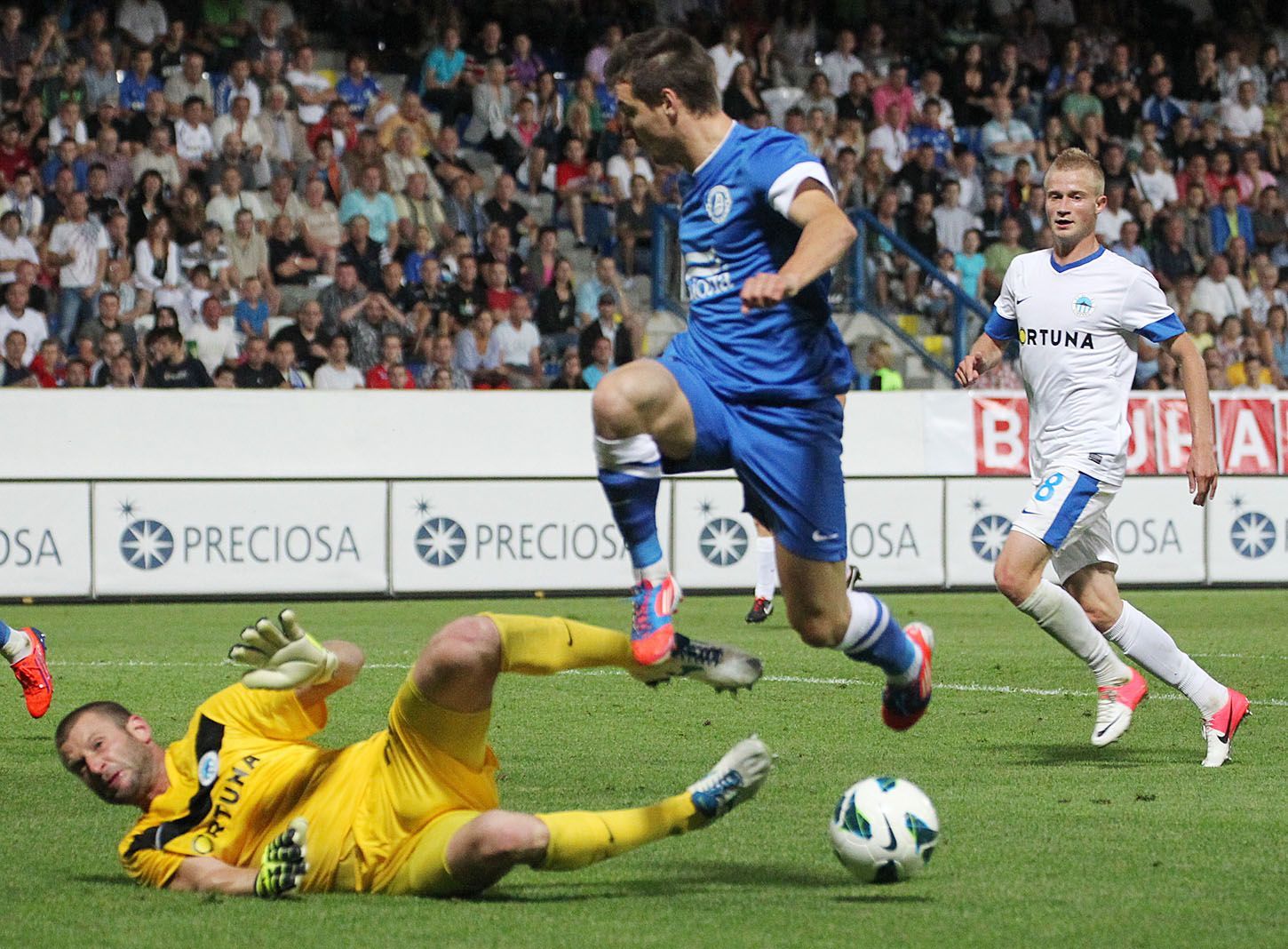 Fotbalový brankář David Bičík ze Slovanu Liberec zastavuje pod dohledem Sergeje Ljulky (vpravo) hráče Dnipra v utkání Evropské ligy s Dněprem Dněpropetrovsk.