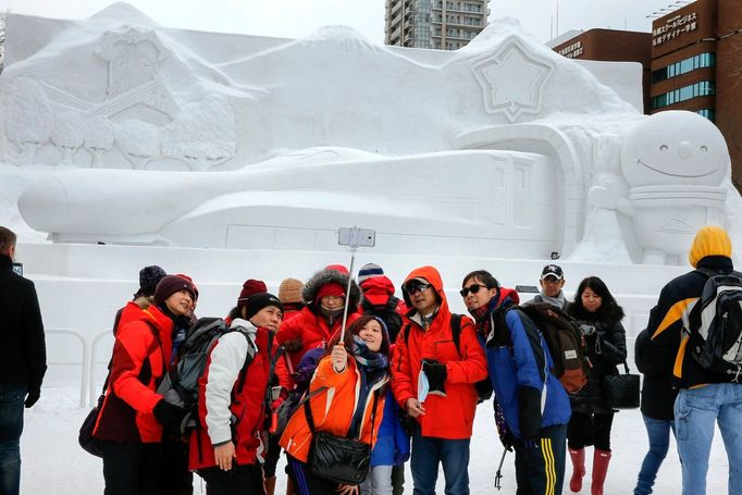 Turisté se fotí před sněhovou sochou vlaku Šinkansen na 67. Sapporo Snow Festivalu, Japonsko, 5. února 2016.