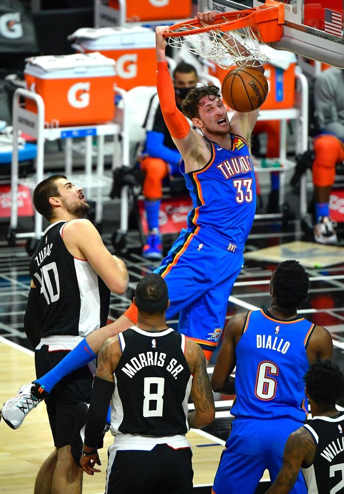 Jan 22, 2021; Los Angeles, California, USA; Oklahoma City Thunder center Mike Muscala (33) slam dunks between LA Clippers center Ivica Zubac (40) and forward Marcus Morri