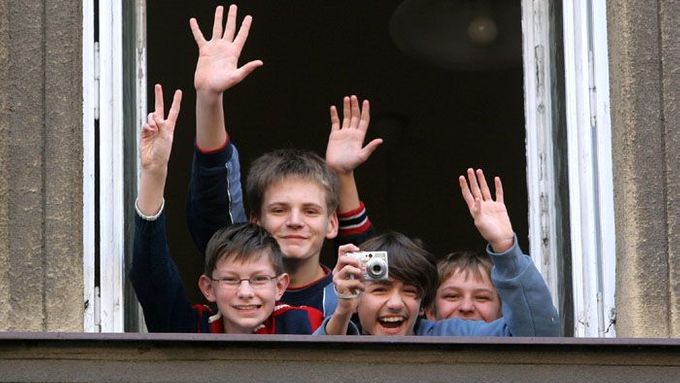 Děti mávají z okna jedné ze škol v polském Cieszyně. Teď v tomto městě přibývá rodičů, kteří své děti posílají do školek a škol na české straně hranice, do Českého Těšína.
