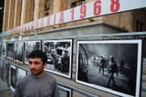 Muž stojí u panelu s fotografiemi zachycujícími napadení Československa v roce 1968. Fotografie byly umístěny před hlavní vchod gruzínského parlamentu.