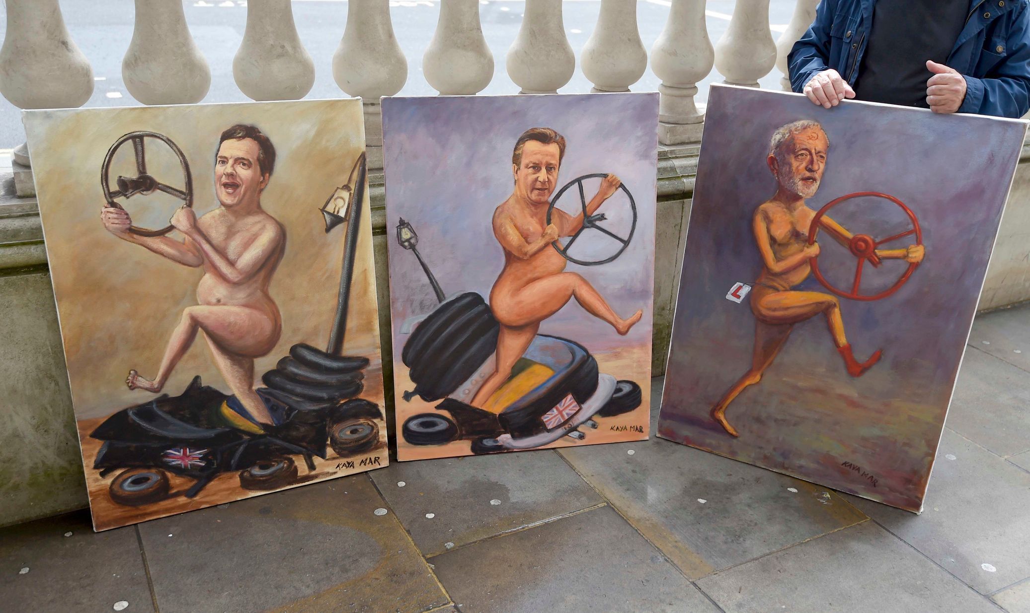 Umělec vystavuje portréty ministra financí George Osborna, premiéra Davida Camerona a předáka Labouristické strany Jeremy Corbyna na londýnské ulici.