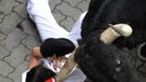 A runner is dragged by his scarf by a Dolores Aguirre fighting bull at the entrance to the bullring during the first running of the bulls of the San Fermin festival in Pamplona July 7, 2012. One person was gored and four others injured in a run that lasted two minutes and fifty-two seconds, according to local media. REUTERS/Vincent West (SPAIN - Tags: ANIMALS SOCIETY TPX IMAGES OF THE DAY) Published: Čec. 7, 2012, 7:51 dop.