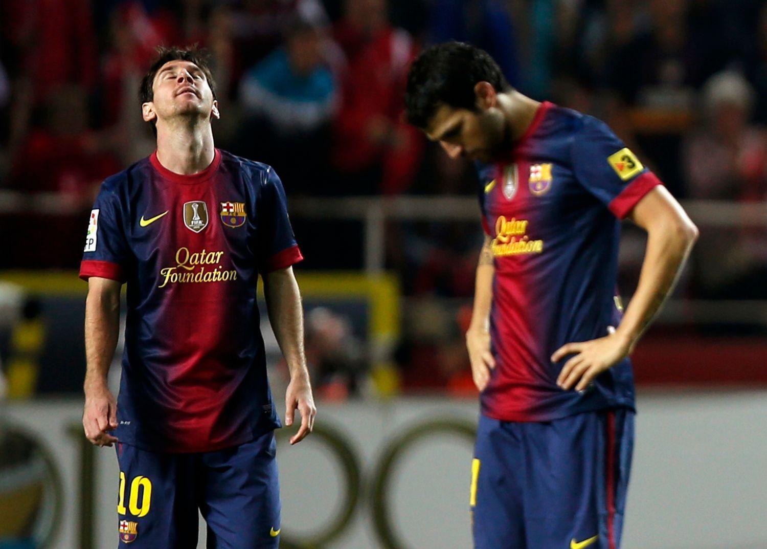 Fotbalisté Barcelony Lionel Messi a Cesc Fabregas po inkasovaném gólu v utkání španělské La Ligy 2012/13 se Sevillou.