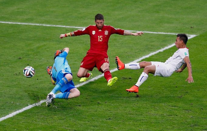 Chile's Eduardo Vargas (R) shoots to score past Spain's Iker Casillas (L) and Sergio Ramos during their 2014 World Cup Group B soccer match at the Maracana stadium in Rio