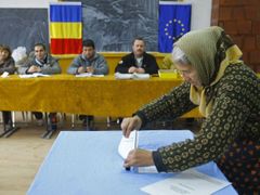 Žena vhazující volební lístek do urny ve městě Gostinari