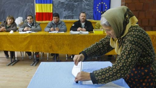 Žena vhazující volební lístek do urny ve městě Gostinari