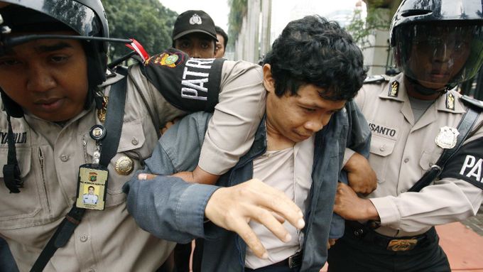Policie odvádí jednoho z účastníků protestu před hlavním vchodem na stadión v centru Jakarty