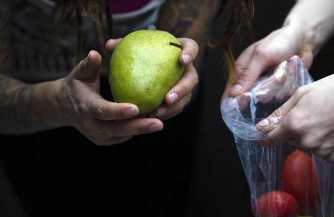 Mya Wollf (R), 28, and Robin Pickell, 23, practising 'freegans', sort through food they recently found in a dumpster behind Commercial Drive in Vancouver, British Columbia April 10, 2012. A 'Freegan' is someone who gathers edible food from the garbage bins of grocery stores or food stands that would otherwise have been thrown away. Freegans aim to spend little or no money purchasing food and other goods, not through financial need but to try to address issues of over-consumption and excess. Picture taken April 10, 2012. REUTERS/Ben Nelms (CANADA - Tags: SOCIETY) ATTENTION EDITORS PICTURE 05 OF 21 FOR PACKAGE 'DUMPSTER DIVING FOR FOOD' Published: Kvě. 15, 2012, 11:58 dop.