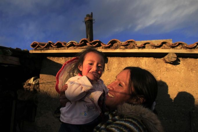 Marathon runner Gladys Tejeda, the first Peruvian athlete who qualified for the 2012 London Olympic Games, holds her niece Ariana at her home in the Andean province of Junin May 13, 2012. A private company will take Tejeda's mother Marcelina Pucuhuaranga, 69, to London as part of the "Thank you Mom" program. For Pucuhuaranga, who received her first passport, it will be the first time travelling out of Peru. The program will take about 120 mothers of different athletes around the world to attend the games. Tejeda, the youngest of nine children, returned to her hometown to visit her mother and to focus on training where she will run more than 20 km every day in the highlands (over 4,105 meters above sea level). Picture taken May 13, 2012. REUTERS/Pilar Olivares (PERU - Tags: SPORT ATHLETICS OLYMPICS) Published: Kvě. 17, 2012, 5:55 odp.