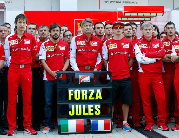 Members of Ferrari Formula One team pose with a sign in support of Marussia Formula One driver Jules Bianchi of France before the first Russian Grand Prix in Sochi Octobe