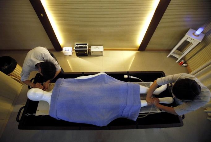 Students practice with a mannequin during their undertaker service class at the Tianquanjiajing Funeral Service school in Jiaxing, Zhejiang province May 29, 2012. A new breed of young Chinese undertakers are fighting centuries-old taboos to gain social acceptance for their profession, saying they help the deceased and their families make their final parting with respect. There are more than 1,500 students across the country studying to become undertakers each year. Courses in funeral services take three years to complete and the service includes washing of the dead body as well as providing funeral make-up and dressing. Picture taken May 29, 2012. REUTERS/Carlos Barria (CHINA - Tags: SOCIETY) ATTENTION EDITORS - PICTURE 13 OF 17 FOR PACKAGE 'FUNERAL SERVICE STUDENTS' Published: Čer. 7, 2012, 2:44 dop.