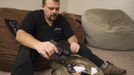 Phil Burns pulls a gun from his backpack full of survival supplies at his home in American Fork, Utah, December 14, 2012. While most "preppers" discount the Mayan calendar prophecy, many are preparing to be self-sufficient for threats like nuclear war, natural disaster, famine and economic collapse. Picture taken December 14, 2012. REUTERS/Jim Urquhart (UNITED STATES - Tags: SOCIETY) Published: Pro. 18, 2012, 5:23 odp.