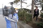 Televizní štáby navozují mezi dvěma stromy iluzi lesa.