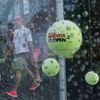 Decorative tennis balls hang on wires in the rain as quarterfinals play between Halep of Romania and Azarenka of Belarus is suspended due to weather at the U.S. Open Championships tennis tournament in