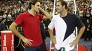 Roger Federer (vlevo) si v průběhu exhibičního zápasu v Macau povídá se svým soupeřem Petem Samprasem.