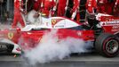 Ferrari F1 driver Kimi Raikkonenin (L) walks away from his car after it caught fire in pit lane during the Australian Formula One Grand Prix in Melbourne. REUTERS/Brandon