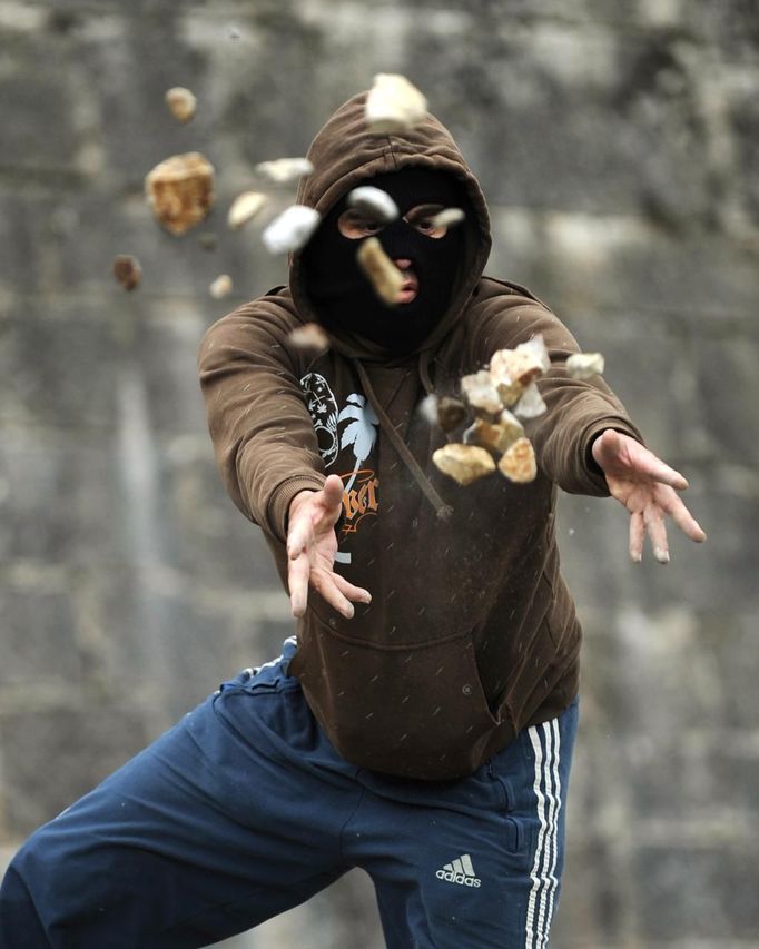 A coal miner throws rocks on a barricade during a protest against government spending cuts in the mining sector along National Highway 630 in Cinera, northern Spanish province of Leon, June 11, 2012. REUTERS/Eloy Alonso (SPAIN - Tags: CIVIL UNREST BUSINESS EMPLOYMENT ENERGY) Published: Čer. 11, 2012, 3:47 odp.