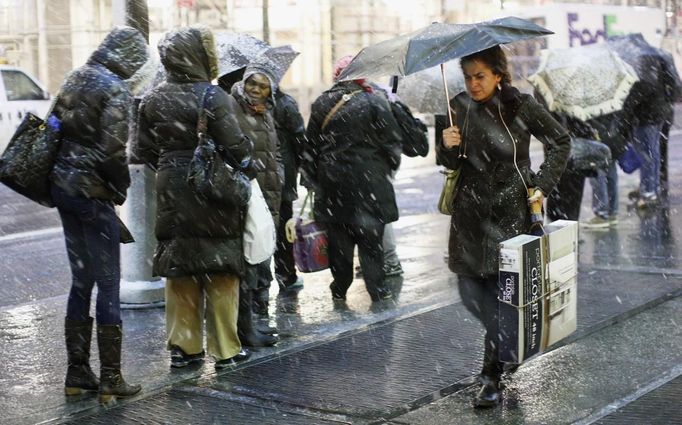 People wait at a bus stop during a snow storm in New York's financial district, November 7, 2012. A wintry storm dropped snow on the Northeast and threatened to bring dangerous winds and flooding to a region still climbing out from the devastation of superstorm Sandy. REUTERS/Brendan McDermid (UNITED STATES - Tags: DISASTER ENVIRONMENT TRANSPORT) Published: Lis. 8, 2012, 12:03 dop.