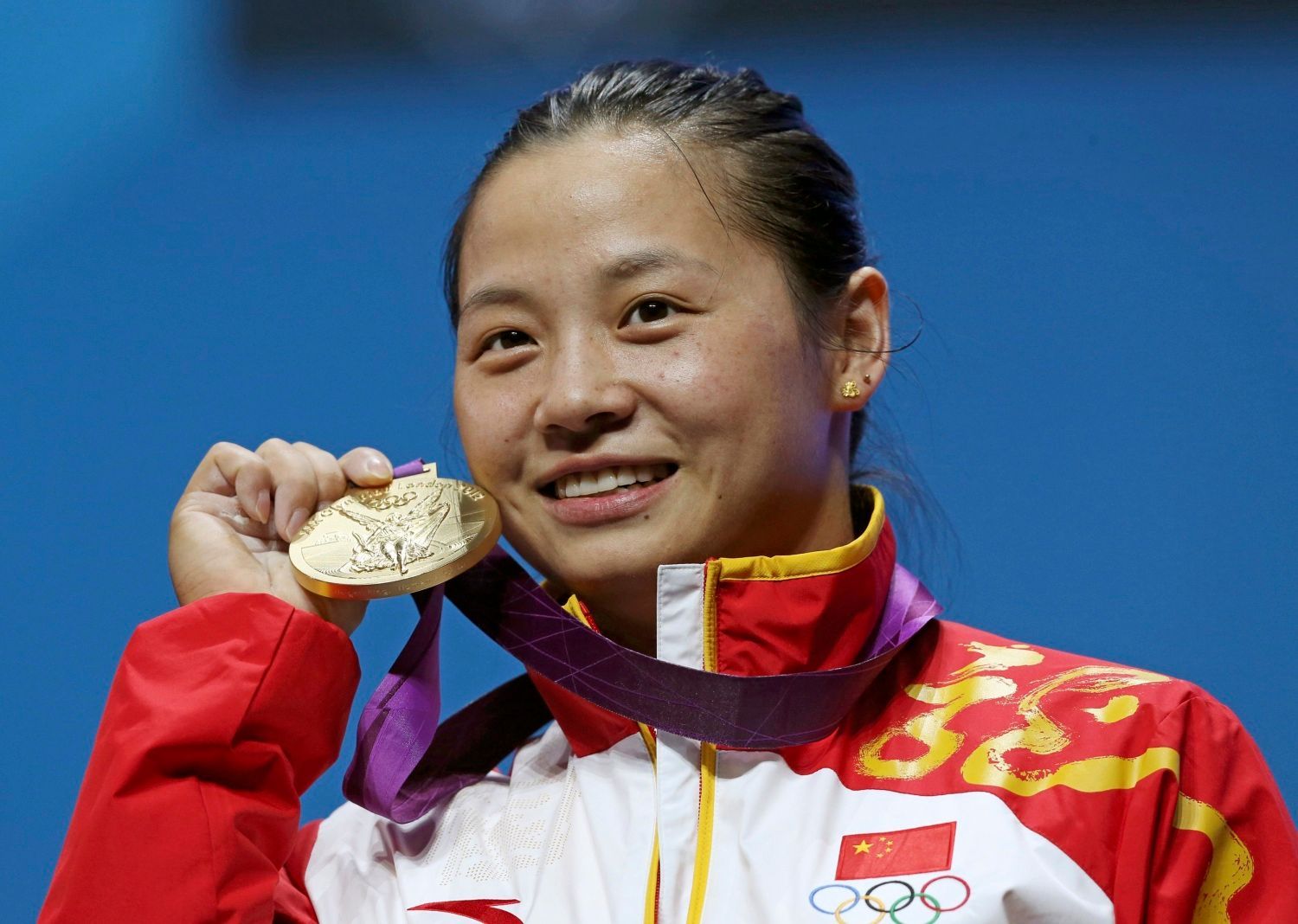 Čínská vzpěračka LI Xueying pózuje se zlatou medailí v kategorii žen do 58 kg na OH 2012 v Londýně.
