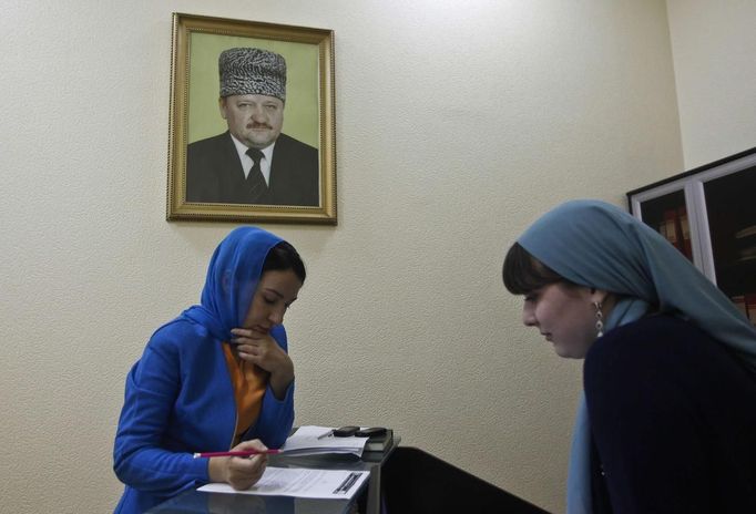 An employee of a memorial complex devoted to former Chechen leader Akhmad Kadyrov signs documents in the Chechen capital Grozny April 26, 2013. The naming of two Chechens, Dzhokhar and Tamerlan Tsarnaev, as suspects in the Boston Marathon bombings has put Chechnya - the former site of a bloody separatist insurgency - back on the world's front pages. Chechnya appears almost miraculously reborn. The streets have been rebuilt. Walls riddled with bullet holes are long gone. New high rise buildings soar into the sky. Spotless playgrounds are packed with children. A giant marble mosque glimmers in the night. Yet, scratch the surface and the miracle is less impressive than it seems. Behind closed doors, people speak of a warped and oppressive place, run by a Kremlin-imposed leader through fear. Picture taken April 26, 2013. REUTERS/Maxim Shemetov (RUSSIA - Tags: SOCIETY POLITICS) ATTENTION EDITORS: PICTURE 28 OF 40 FOR PACKAGE 'INSIDE MODERN CHECHNYA'. SEARCH 'REBUILDING CHECHNYA' FOR ALL IMAGES Published: Kvě. 1, 2013, 8:11 dop.