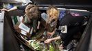 Mya Wollf (R), 28, and Robin Pickell, 23, who are both 'freegans', sort through a dumpster for edible food in an alley behind Commercial Drive in Vancouver, British Columbia April 10, 2012. A 'Freegan' is someone who gathers edible food from the garbage bins of grocery stores or food stands that would otherwise have been thrown away. Freegans aim to spend little or no money purchasing food and other goods, not through financial need but to try to address issues of over-consumption and excess. Picture taken April 10, 2012. REUTERS/Ben Nelms (CANADA - Tags: SOCIETY) ATTENTION EDITORS PICTURE 03 OF 21 FOR PACKAGE 'DUMPSTER DIVING FOR FOOD' Published: Kvě. 15, 2012, 11:57 dop.