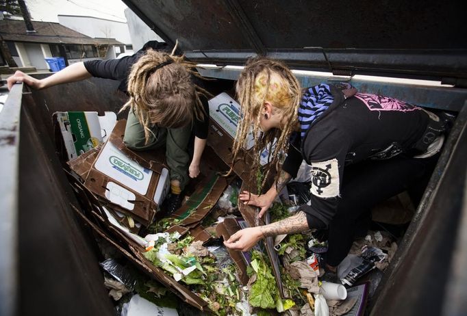 Mya Wollf (R), 28, and Robin Pickell, 23, who are both 'freegans', sort through a dumpster for edible food in an alley behind Commercial Drive in Vancouver, British Columbia April 10, 2012. A 'Freegan' is someone who gathers edible food from the garbage bins of grocery stores or food stands that would otherwise have been thrown away. Freegans aim to spend little or no money purchasing food and other goods, not through financial need but to try to address issues of over-consumption and excess. Picture taken April 10, 2012. REUTERS/Ben Nelms (CANADA - Tags: SOCIETY) ATTENTION EDITORS PICTURE 03 OF 21 FOR PACKAGE 'DUMPSTER DIVING FOR FOOD' Published: Kvě. 15, 2012, 11:57 dop.