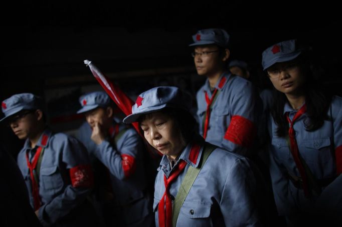 Mid-level government officials dressed in red army uniforms walk inside an old house where former Chinese leader Mao Zedong used to live during their 5-day training course at the communist party school called China Executive Leadership Academy of Jinggangshan, in Jiangxi province, in this September 21, 2012 file photo. China's Communist Party has dramatically stepped up its training of the country's roughly 40 million party and government officials in the past decade. With public scrutiny of cadre behaviour growing via social media, the party is likely to call for continued, and deepened, cadre education at the upcoming 18th Party Congress. At the vanguard of this education drive, alongside a Central Party School in Beijing, are three "Executive Leadership Academies" which opened in 2005 for middle-ranking and senior officials in Shanghai, Yan'an and Jinggangshan. The curriculum covers Marxism, Leninism and Mao Zedong Thought, but students may also take finance courses, receive in-depth media training or role-play crisis management scenarios on everything from disease outbreaks to train wrecks. REUTERS/Carlos Barria/Files (CHINA - Tags: POLITICS SOCIETY TPX IMAGES OF THE DAY) Published: Zář. 24, 2012, 1:32 odp.