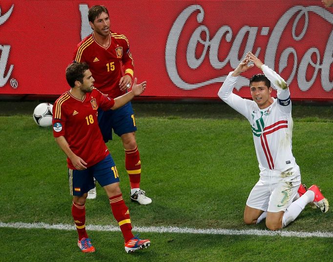 Cristiano Ronaldo gestikuluje a sledují ho při tom Jordi Alba (vlevo) a Sergio Ramos během semifinálového utkání mezi Portugalskem a Španělskem na Euru 2012.