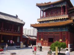 Kontrast chrámu s pekingskými paneláky v pozadí.