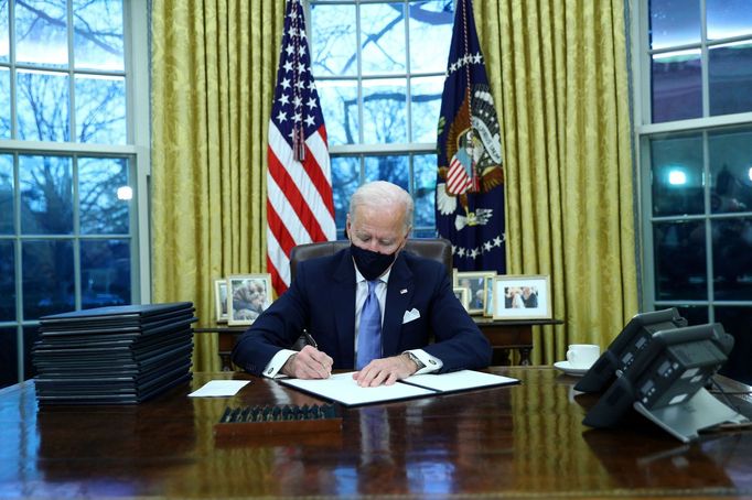 Americký prezident Joe Biden podepisuje v Oválné pracovně exekutivní příkazy pár hodin po své inauguraci.