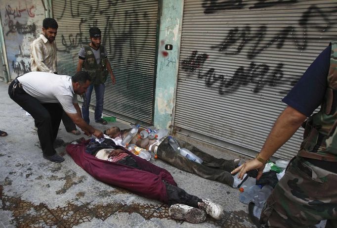 Free Syrian Army members place frozen water bottles on the bodies of civilians killed by shelling, to prevent rapid decomposition, in Aleppo July 29, 2012. REUTERS/Zohra Bensemra (SYRIA - Tags: CIVIL UNREST MILITARY POLITICS CONFLICT) Published: Čec. 29, 2012, 3:31 odp.