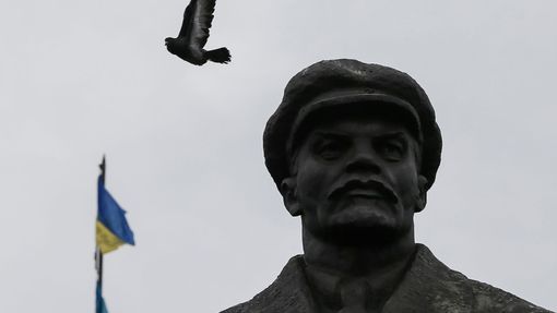 Holub letící nad vztyčenou ukrajinskou vlajkou před kanceláří starosty ve Slavjansku.
