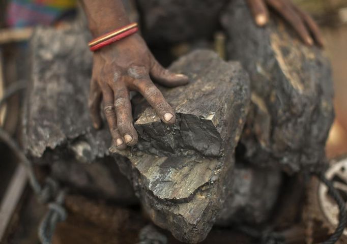 A local woman prepares to carry coal at an open coal field at Dhanbad district in the eastern Indian state of Jharkhand September 19, 2012. With oil and gas output disappointing and hydropower at full throttle, Asia's third-largest economy still relies on coal for most of its vast energy needs. About 75 percent of India's coal demand is met by domestic production and, according to government plans, that won't change over the next five years. Picture taken September 19, 2012. To match INDIA-COAL/ REUTERS/Ahmad Masood (INDIA - Tags: BUSINESS EMPLOYMENT ENERGY SOCIETY ENVIRONMENT) Published: Říj. 21, 2012, 10:13 odp.