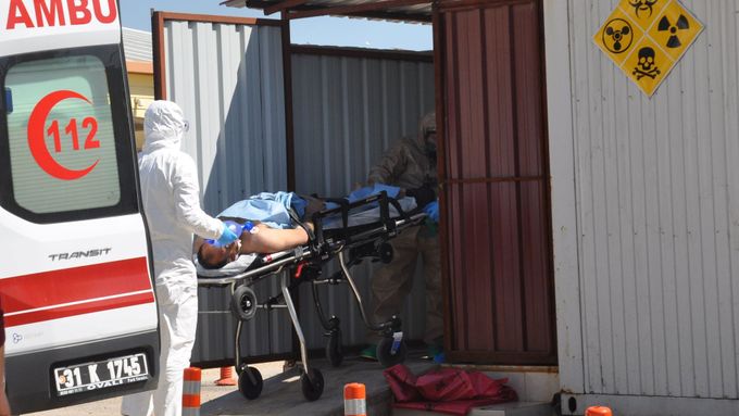Turečtí zdravotníci vezou zraněného muže od syrského Idlíbu.