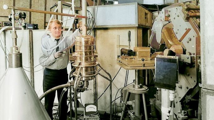 První experiment s použitím supravodivého magnetu v CERN, 1965. Fyzik upravuje kryostat s jadernými emulzemi a supravodivým magnetem chlazeným heliem.